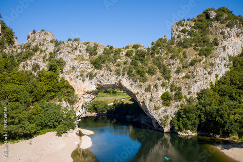 The river flows under the Pont dArc in the Gorges de lArdeche in Europe  France  Ardeche  in summer  on a sunny day.