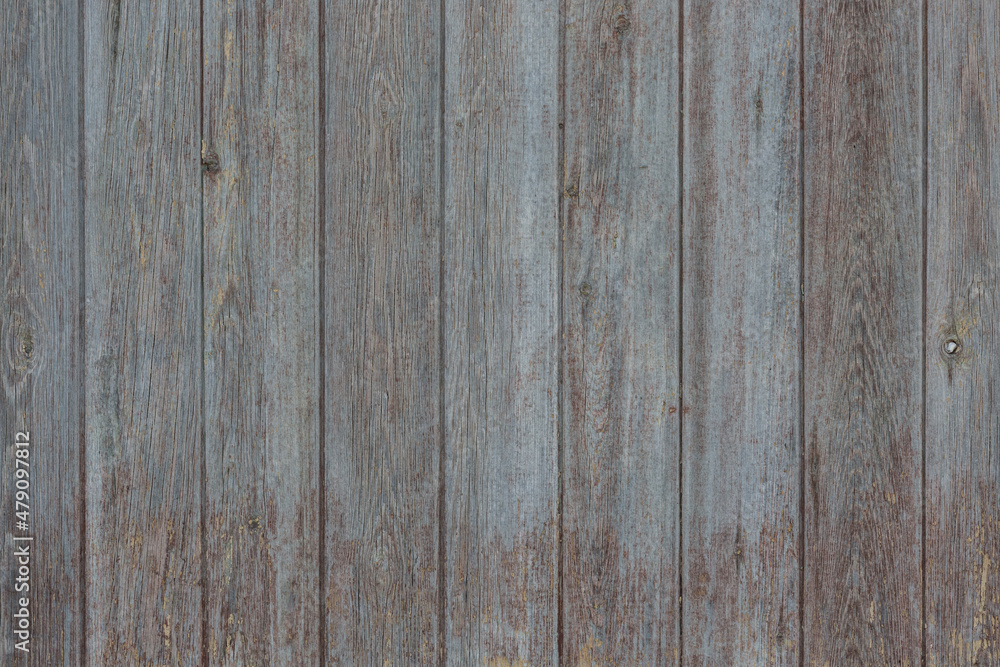 An old fence made of vertically assembled boards. Background, texture.