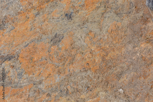 The surface has a rough stone texture with a rusty tinge. Background for designers.