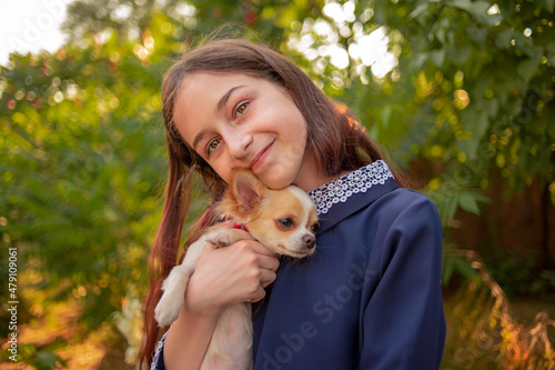 Teenage girl with a dog. Girl rejoices hugging Chihuahua. Man and the animal world.