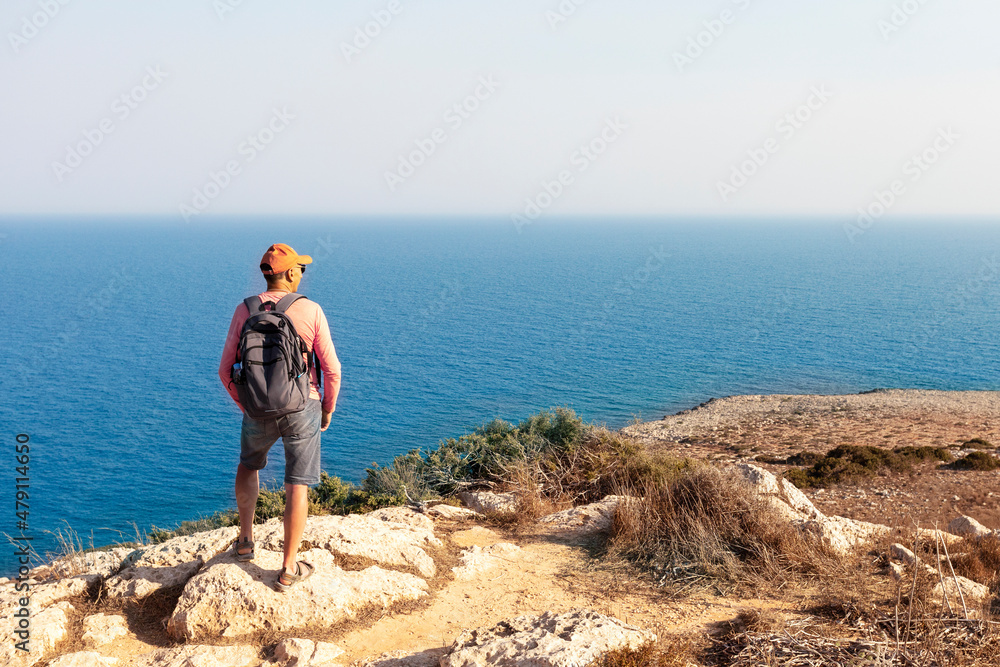 Mature man, hiking by the sea and exploring the nature.  Freedom and Healthy Lifestyle concept.