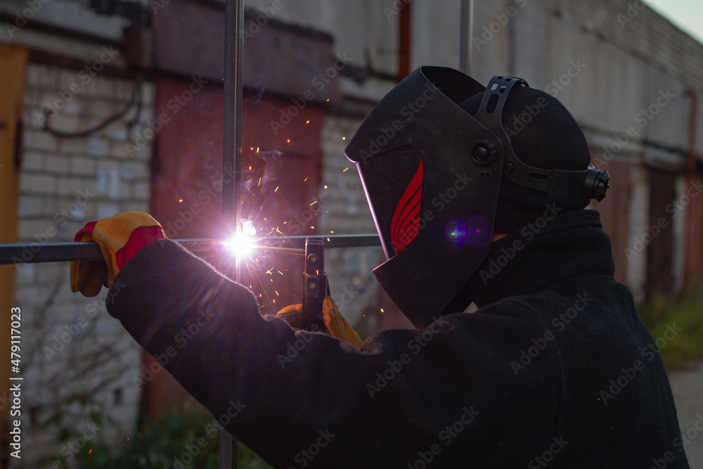 Foto de A man in a mask welds the construction. Industrial worker at a