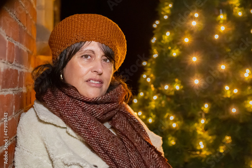 Portrait of a woman with a woolen hat - Christmas lights background.