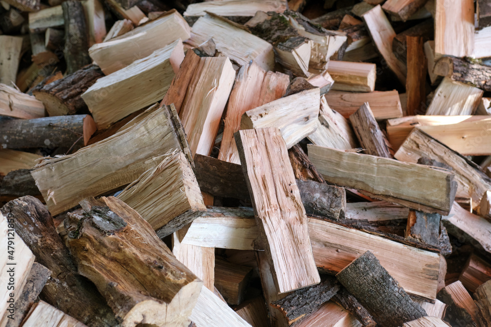 Small brown chopped firewood with grey bark pile lies Small brown chopped firewood with grey bark pile lies