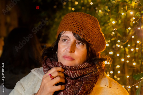 Portrait of a woman with a woolen hat - Christmas lights background.