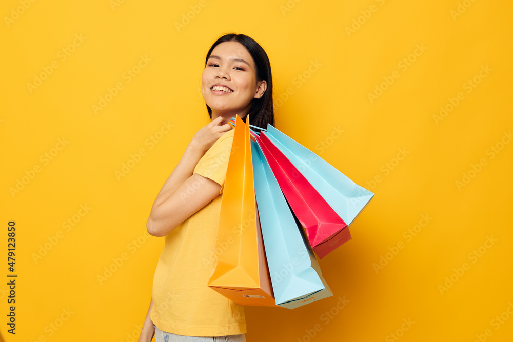 Portrait Asian beautiful young woman with packages in hands shopping studio model unaltered Portrait Asian beautiful young woman with packages in hands shopping studio model unaltered