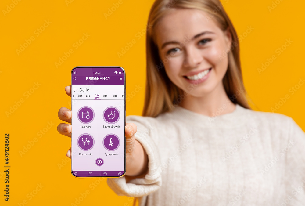 Cheerful pregnant woman showing mobile application for pregnancy Cheerful pregnant woman showing mobile application for pregnancy
