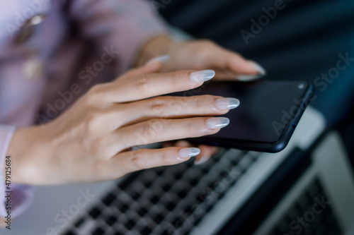 woman sitting on the sofa and holding the phone © Abdul