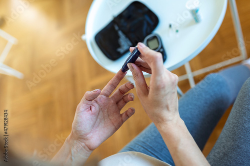 Test Blood Glucose For Diabetes in Pregnant Woman With Glucometer. One red drop of blood on the finger ready to measure sugar level. Close up of male finger with blood drop and test stripe