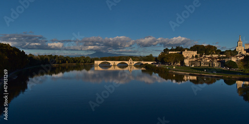 Panoramic view of calm Rhone river with famous historic bridge Pont Saint-Benezet, UNESCO World Heritage Site, in city Avignon, Provence, France.