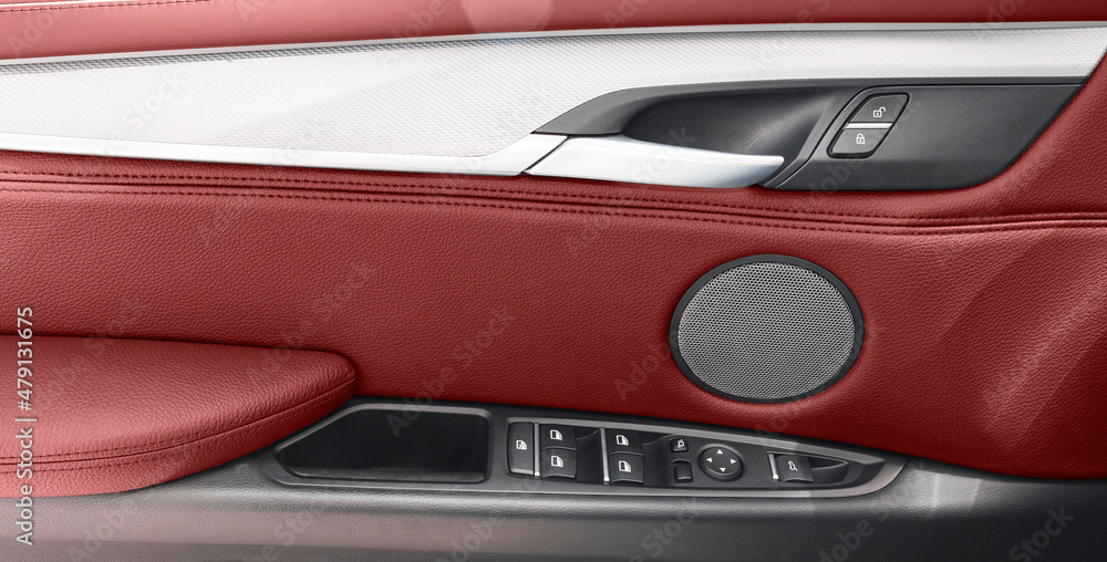 Car door handle inside the luxury modern car with red leather. Switch button control. Modern car interior details. Red perforated leather