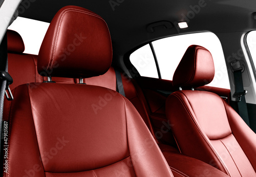 Luxury car red leather interior. Part of leather car seat details with stitching. Comfortable perforated red leather seats. Red perforated leather. Car inside © Aleksei