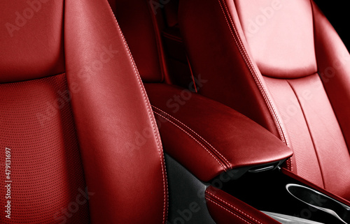 Luxury car red leather interior. Part of leather car seat details with stitching. Comfortable perforated red leather seats. Red perforated leather. Car inside © Aleksei