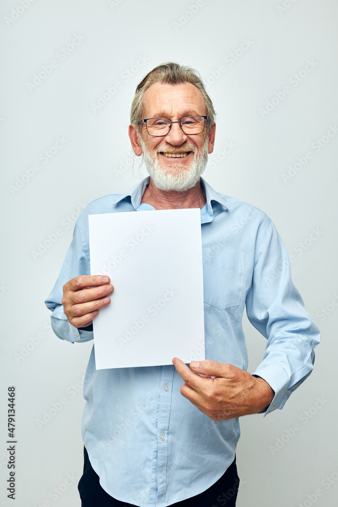 Portrait elderly man holding a sheet of paper copy-space posing cropped view Portrait elderly man holding a sheet of paper copy-space posing cropped view