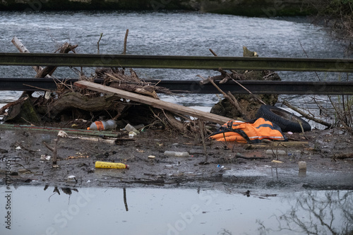 polluted canal with rubbish gathered on weir