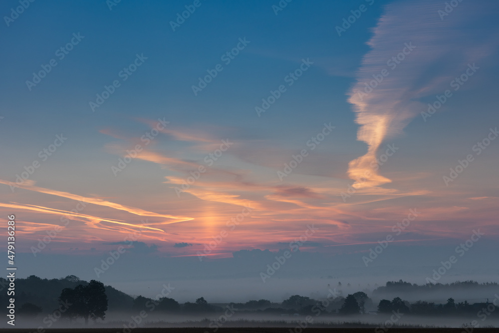 UK misty morning landscape with blue skies and clouds at sunrise