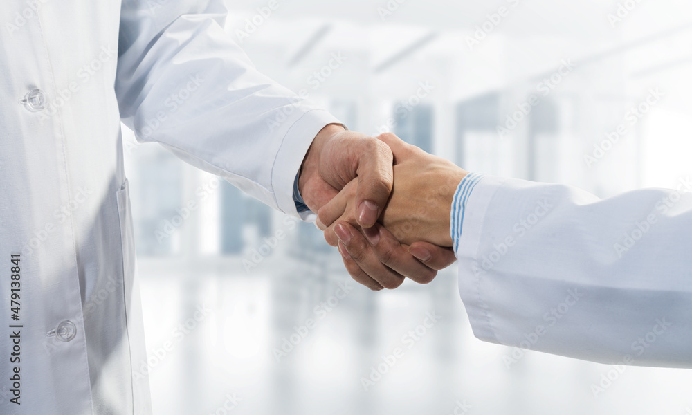 Close-up of the handshake between the two medics. Against the backdrop of the cityscape Close-up of the handshake between the two medics. Against the backdrop of the cityscape