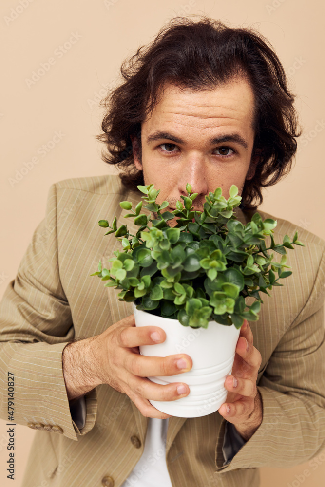 Cheerful man in a suit posing emotions flower pot isolated background Cheerful man in a suit posing emotions flower pot isolated background