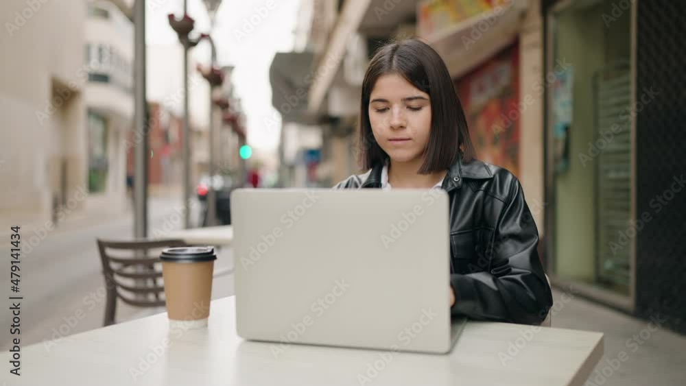 Young hispanic woman using laptop working at coffee shop terrace Young hispanic woman using laptop working at coffee shop terrace
