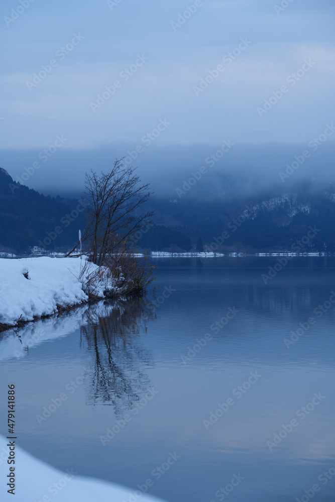 A view of an extremely cold lake covered with snow in the middle of winter. A view of an extremely cold lake covered with snow in the middle of winter.