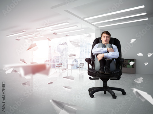 scared businessman on a chair in office