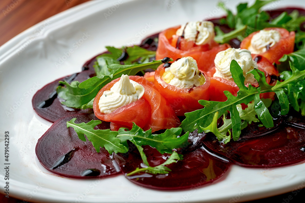 Lightly salted salmon with cream cheese, served with beetroot carpaccio on wooden background Lightly salted salmon with cream cheese, served with beetroot carpaccio on wooden background
