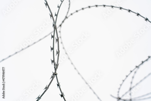 Barbed wire on white cloudy sky background