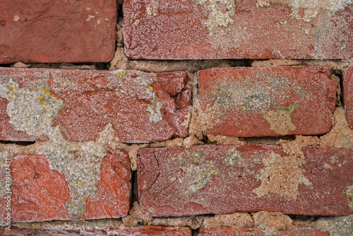 Old red brick stone wall frozen with snow and ice texture