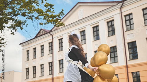 Happy Russian schoolgirl on the last day of school with balloons.