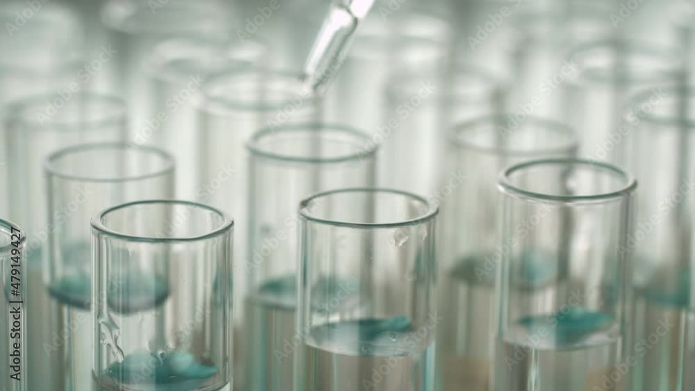 Closeup shot of scientist dripping liquid into test tube. Closeup shot of scientist dripping liquid into test tube.