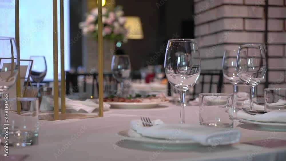 Served table in a restaurant for dinner, lunch or celebration. White tablecloth, plates, napkins and glasses, chairs. Holiday indoors. Empty with no people and food. Served table in a restaurant for dinner, lunch or celebration. White tablecloth, plates, napkins and glasses, chairs. Holiday indoors. Empty with no people and food.