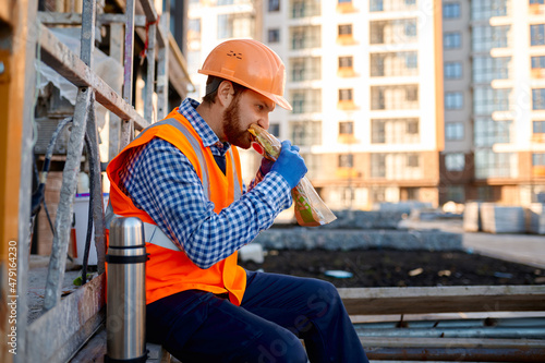 Construction worker eating sandwich during lunch break photo