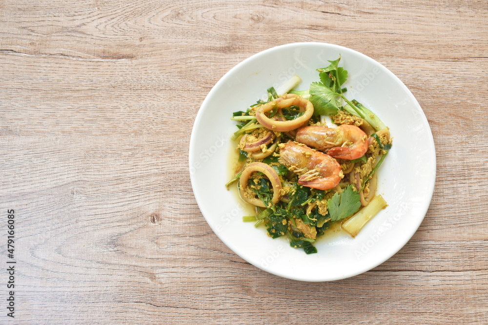 stir fried river shrimp and squid in yellow curry with egg on plate stir fried river shrimp and squid in yellow curry with egg on plate