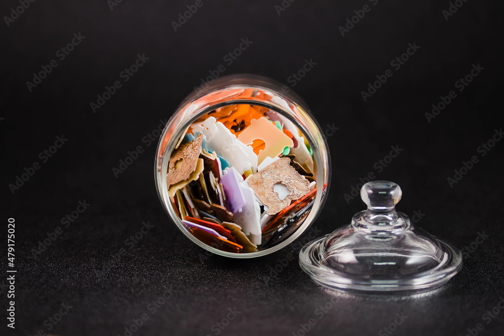 a glass jar filled with lots of multicolored plastic bread tags a glass jar filled with lots of multicolored plastic bread tags