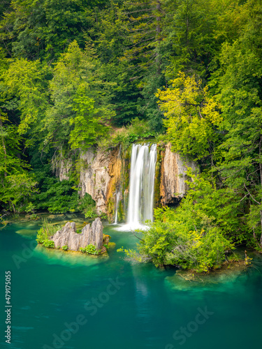 Last sunlight lights up the pure water waterfall on Plitvice National Park. Colorful spring panorama of green forest with blue lake. Great countryside view of Croatia, Europe.