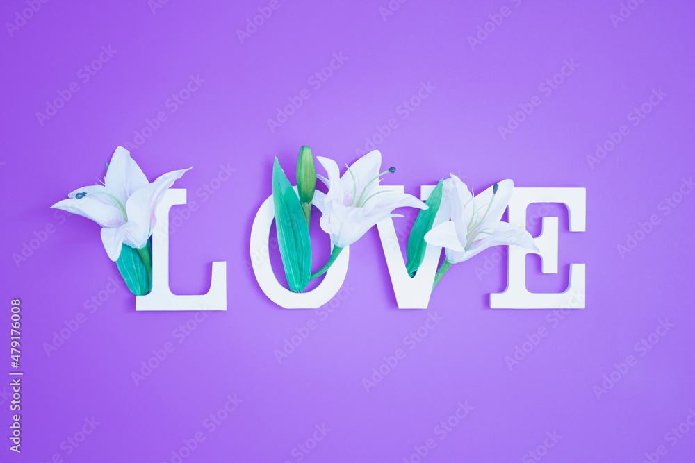 Fototapeta premium Colorful love background. Floral Greeting card. Happy Women's Day. Spring flower flat lay holiday background with word Love. Nature Trendy Design. Happy Valentine's Day.