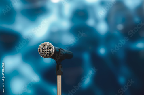 Microphone with stage lighting background for performance concept of speech comment and public speaking