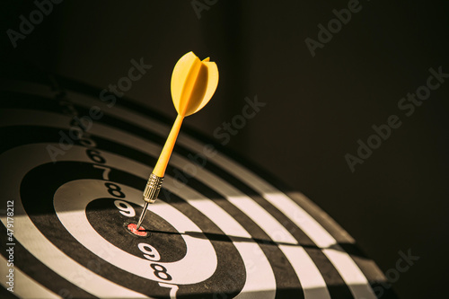 Bullseye target goal or dartboard has dart arrow throw hitting center shooting for financial business targeting planning to winner concept. photo