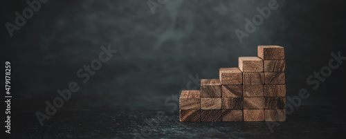 Foto Wood block tower stack in stair step concept of prevent collapse or crash of financial business and risk management or strategic planning