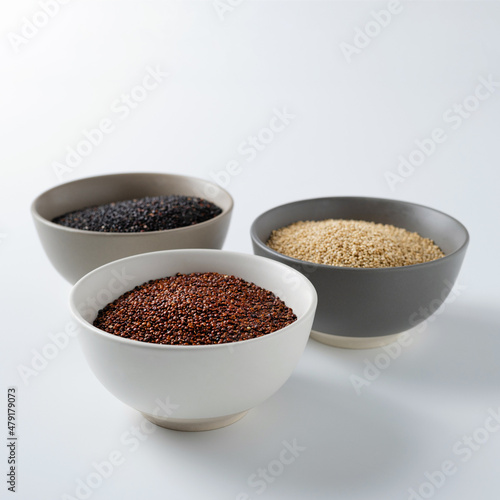 quinoa grain cereal, pseudo-grain, different types and colors in cups, white, black, red quinoa on a white background, square format