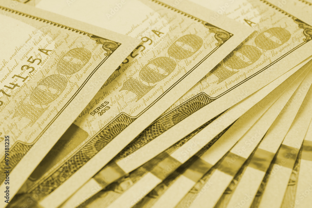 Fototapeta premium American banknotes of one hundred dollars. Fragment of notes close-up. Focus on digit 100. Economy money savings and US dollar. Light olive tinted background or backdrop. Macro