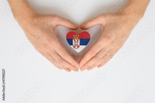 The national flag of Serbia in female hands. The concept of patriotism  respect and solidarity with the citizens of Serbia.