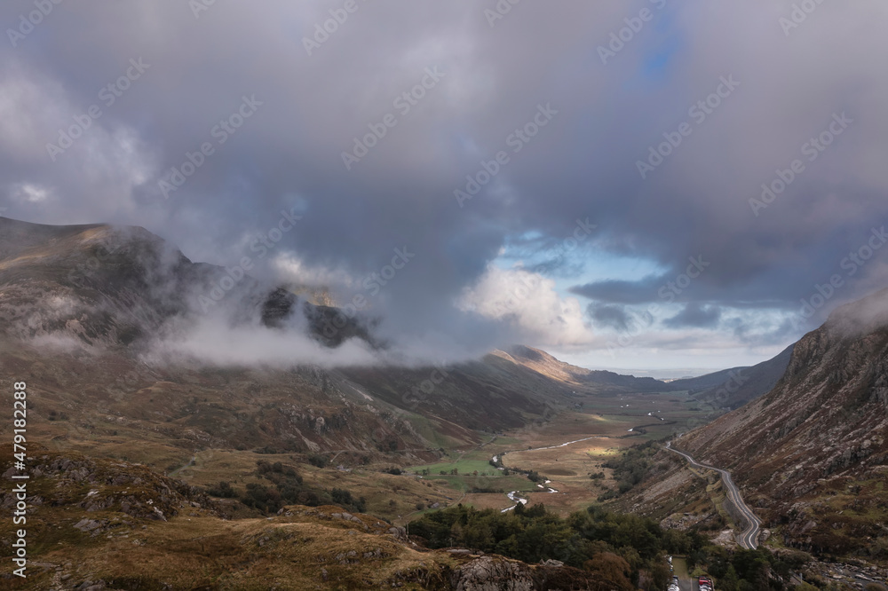 Aerial view of flying drone Epic landscape image in Autumn looking down Nant Fracon valley from Llyn Idwal with moody sky and copyspace