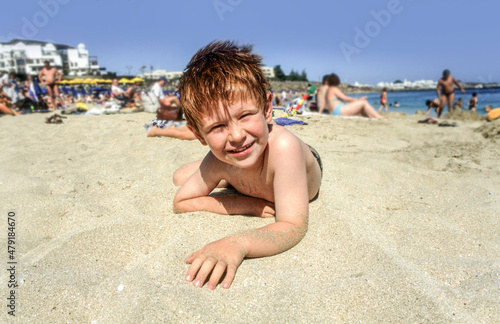 boy enjoys lying in the sand of the beautiful beach