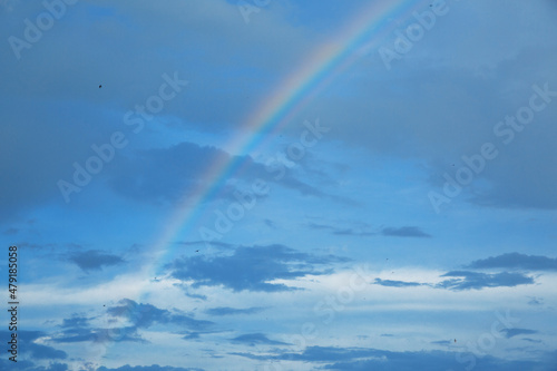 Rainbow in the blue sky with clouds © Eno1