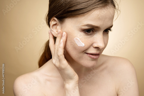 Uses natural cosmetics cream scrub. Woman portrait clean skin face, care and moisturizing.