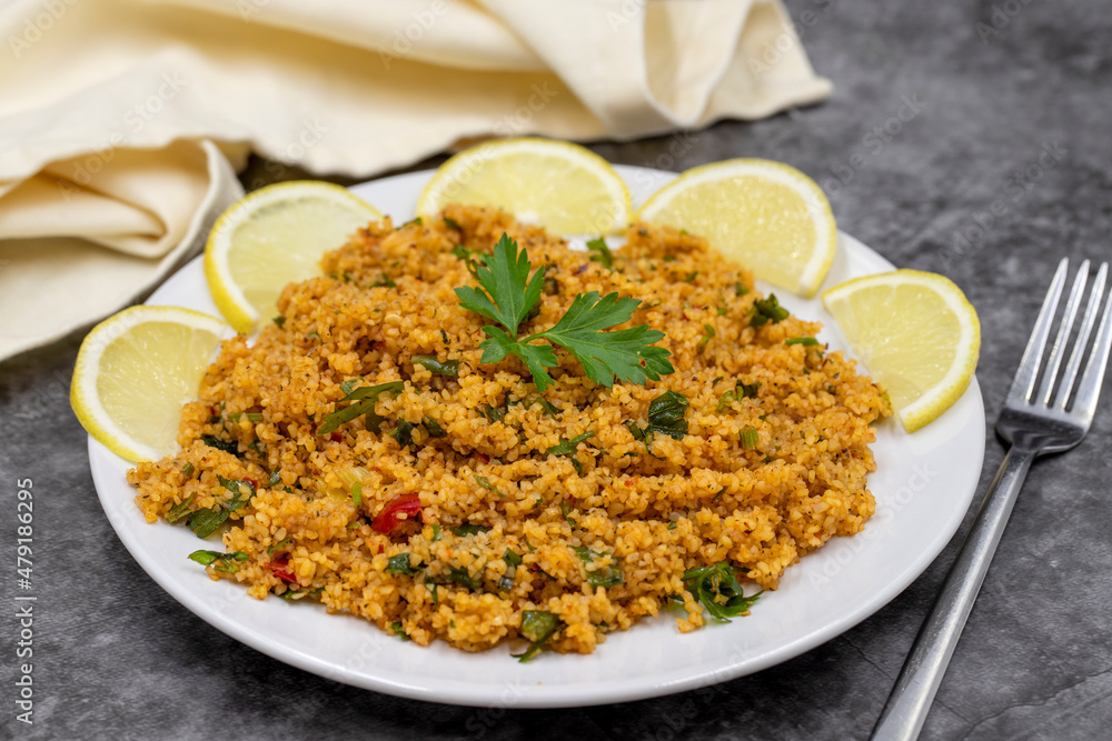 Bulgur salad (kisir) on a dark background. Traditional delicious food. Turkish cuisine appetizers. Horizontal view. close up Bulgur salad (kisir) on a dark background. Traditional delicious food. Turkish cuisine appetizers. Horizontal view. close up