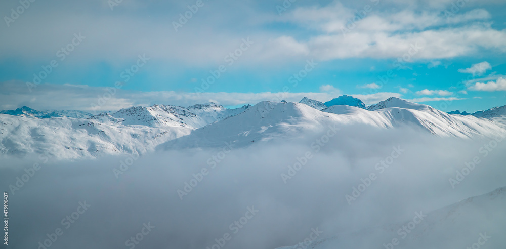 Obraz premium Beautiful alpine panorama of mountain peaks above clouds in the Italian Alps near Livigno