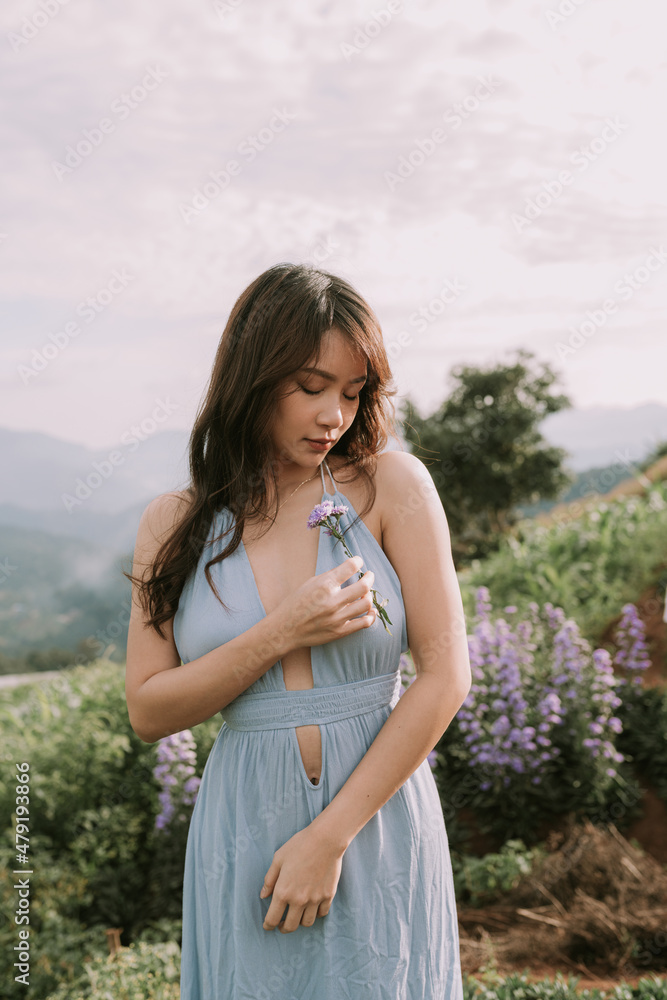 Portrait of thai young woman enjoying in blooming flower field Portrait of thai young woman enjoying in blooming flower field