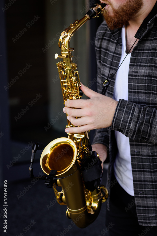 Obraz premium Hands of young musician man plays on saxophone